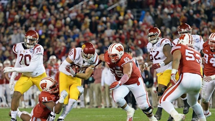 Dec 30, 2015; San Diego, CA, USA; USC Trojans tight end Tyler Petite (82) is defended by Wisconsin Badgers defensive end Chikwe Obasih (34) and defensive lineman Olive Sagapolu (65) during the second quarter in the 2015 Holiday Bowl at Qualcomm Stadium. Mandatory Credit: Jake Roth-USA TODAY Sports