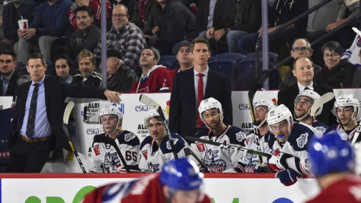 LAVAL, QC - OCTOBER 30: Head coach of the Hartford Wolf Pack Kris Knoblauch (C) watches from the bench with associate head coach Gord Murphy (L) and assistant coach David Cunniff against the Laval Rocket during the third period at Place Bell on October 30, 2019 in Laval, Canada. The Laval Rocket defeated the Hartford Wolf Pack 4-1. (Photo by Minas Panagiotakis/Getty Images)