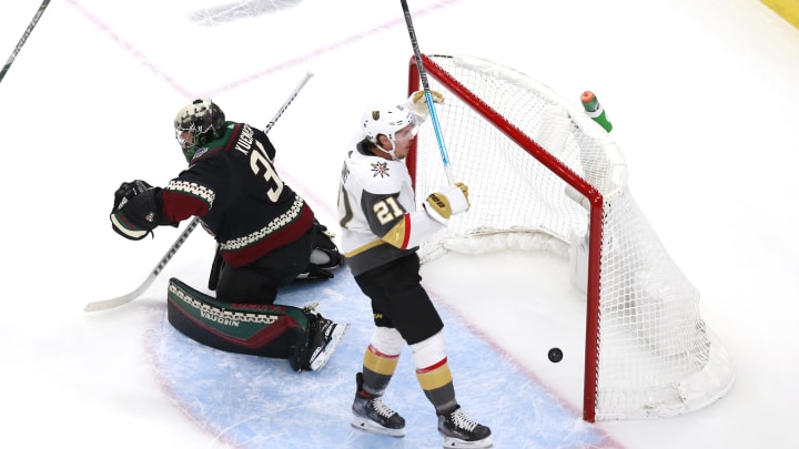 Darcy Kuemper #35 of the Arizona Coyotes is unable to stop a power play goal by Reilly Smith of the Vegas Golden Knights as Nick Cousins #21 of the Vegas Golden Knights celebrates.