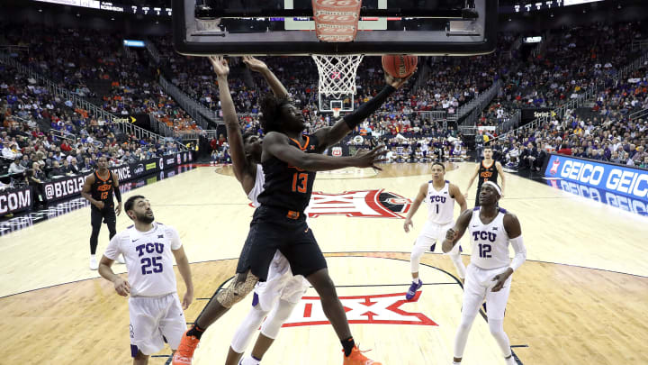 KANSAS CITY, MISSOURI – MARCH 13: Isaac Likekele #13 of the Oklahoma State Cowboys drives to the basket as Kevin Samuel #21 of the TCU Horned Frogs defends during the first round game of the Big 12 Basketball Tournament at the Sprint Center on March 13, 2019 in Kansas City, Missouri. (Photo by Jamie Squire/Getty Images)