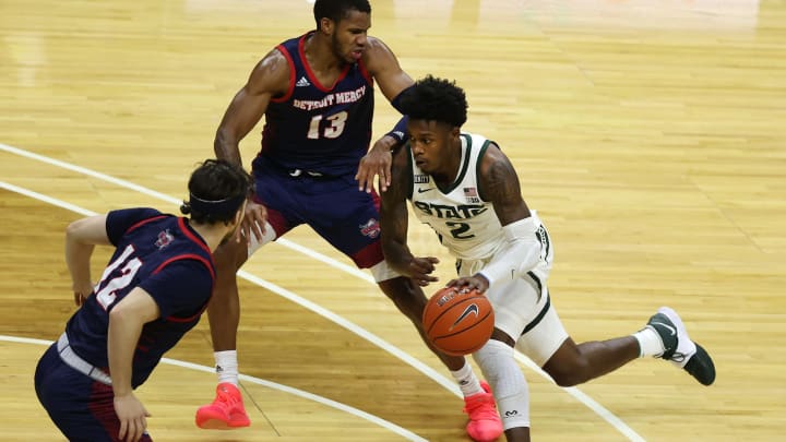 EAST LANSING, MICHIGAN – DECEMBER 04: Rocket Watts #2 of the Michigan State Spartans tries to drive between Matt Johnson #13 and Brad Calipari #12 of the Detroit Titans during the second half at Breslin Center on December 04, 2020 in East Lansing, Michigan. Michigan State won the game 83-76. (Photo by Gregory Shamus/Getty Images)