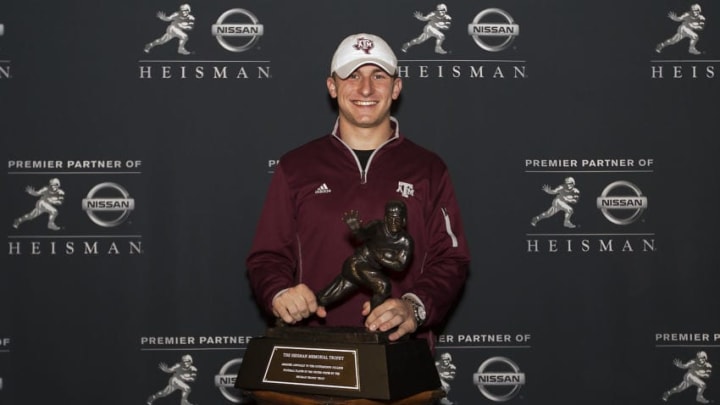 NEW YORK, NY - DECEMBER 13: 2013 Heisman Trophy finalist Johnny Manziel, quarterback of the Texas A&M University Aggies, poses with the Heisman Trophy at the Marriott Marquis on December 13, 2013 in New York City. NOTE TO USER: Photographer approval needed for all Commercial License requests. (Photo by Kelly Kline/Getty Images for The Heisman)