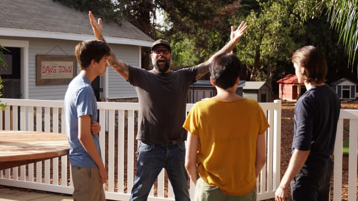 Antonio Bellatore with his arms triumphantly in the air stands with Francesca Cappucci and her sons, Will and Ian, on the remodeled deck. Photo by Animal Planet