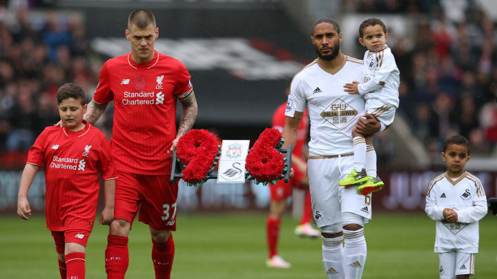 SWANSEA, WALES – MAY 01: Martin Skrtel of Liverpool and Ashley Williams of Swansea City carry a wreath as they remember the 96 victims of the Hillsborough disaster during the Barclays Premier League match between Swansea City and Liverpool at The Liberty Stadium on May 1, 2016 in Swansea, Wales. (Photo by Steve Bardens/Getty Images)