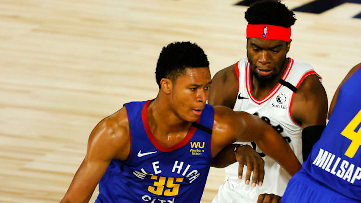LAKE BUENA VISTA, FLORIDA - AUGUST 14: PJ Dozier #35 of the Denver Nuggets drives the ball past Terence Davis #0 of the Toronto Raptors during the second quarter at The Field House at ESPN Wide World Of Sports Complex on August 14, 2020 in Lake Buena Vista, Florida. NOTE TO USER: User expressly acknowledges and agrees that, by downloading and or using this photograph, User is consenting to the terms and conditions of the Getty Images License Agreement. (Photo by Mike Ehrmann/Getty Images)