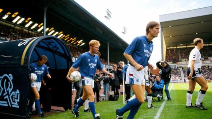 GLASGOW, UNITED KINGDOM – AUGUST 01: Rangers player Mo Johnston (c) makes his way onto the pitch behind Richard Gough for his debut in a pre season friendly against Tottenham Hotspur at Ibrox in August, 1989, Johnston became the first high profile Catholic to play for Rangers, moving from Glasgow Celtic. (Photo by Allsport/Getty Images)