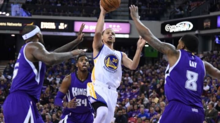 October 29, 2014; Sacramento, CA, USA; Golden State Warriors guard Stephen Curry (30) shoots the basketball against Sacramento Kings center DeMarcus Cousins (15, left), forward Jason Thompson (34), and forward Rudy Gay (8) during the first quarter at Sleep Train Arena. Mandatory Credit: Kyle Terada-USA TODAY Sports