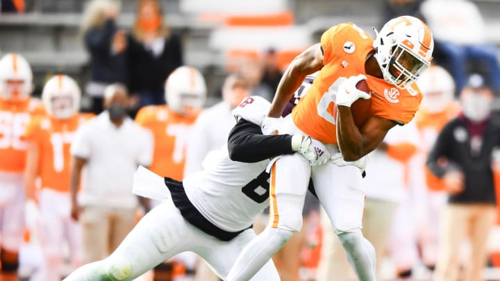 Tennessee running back Ty Chandler (8) is defended by Texas A&M defenisve lineman DeMarvin Leal (8) during a game between Tennessee and Texas A&M in Neyland Stadium in Knoxville, Saturday, Dec. 19, 2020.