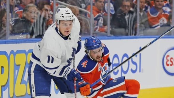 Nov 29, 2016; Edmonton, Alberta, CAN; Toronto Maple Leafs forward Zach Hyman (11) takes the puck from Edmonton Oilers defensemen Kris Russell (4) during the second period at Rogers Place. Mandatory Credit: Perry Nelson-USA TODAY Sports