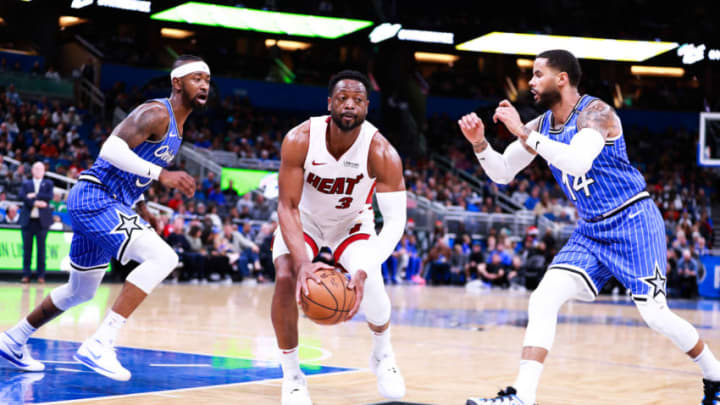 ORLANDO, FLORIDA - DECEMBER 23: D.J. Augustin #14 and Terrence Ross #31 of the Orlando Magic attempt to defend against Dwyane Wade #3 of the Miami Heat in the second quarter at Amway Center on December 23, 2018 in Orlando, Florida. NOTE TO USER: User expressly acknowledges and agrees that, by downloading and or using this photograph, User is consenting to the terms and conditions of the Getty Images License Agreement.(Photo by Harry Aaron/Getty Images)