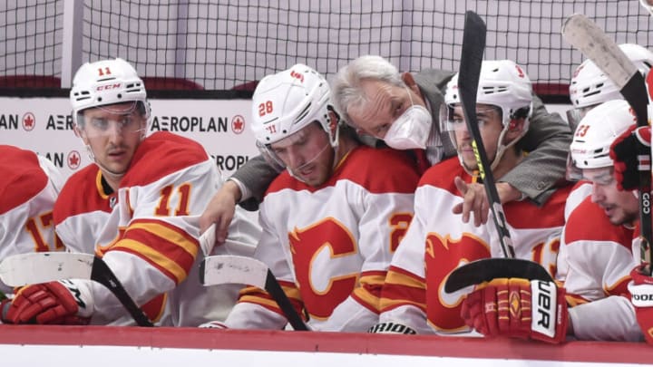 MONTREAL, QC - APRIL 14: Head coach Darryl Sutter of the Calgary Flames speaks with Elias Lindholm #28 and Johnny Gaudreau #13 during the third period against the Montreal Canadiens at the Bell Centre on April 14, 2021 in Montreal, Canada. The Flames defeated the Canadiens 4-1. (Photo by Minas Panagiotakis/Getty Images)