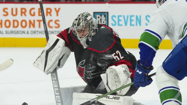 Jan 15, 2023; Raleigh, North Carolina, USA; Carolina Hurricanes goaltender Pyotr Kochetkov (52) makes save against Vancouver Canucks center J.T. Miller (9) during the overtime at PNC Arena. Mandatory Credit: James Guillory-USA TODAY Sports