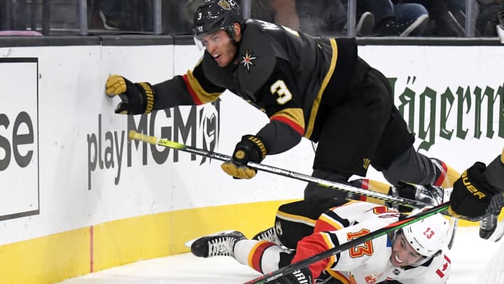 LAS VEGAS, NEVADA – OCTOBER 12: Johnny Gaudreau #13 of the Calgary Flames falls to the ice as he and Brayden McNabb #3 of the Vegas Golden Knights go after the puck in the third period of their game at T-Mobile Arena on October 12, 2019 in Las Vegas, Nevada. McNabb received a two-minute minor penalty for tripping on the play. The Golden Knights defeated the Flames 6-2. (Photo by Ethan Miller/Getty Images)