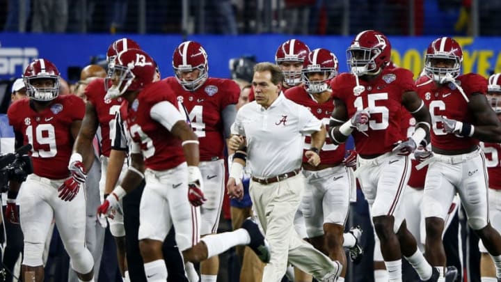ARLINGTON, TX - DECEMBER 31: Head coach Nick Saban of the Alabama Crimson Tide runs out of the tunnel with his team before taking on the Michigan State Spartans in the Goodyear Cotton Bowl at AT