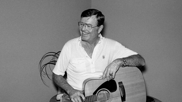 University of Texas athletic director and former head coach Darrell Royal relaxes with a guitar at the offices of Tree Publishing Co. Feb. 23, 1979. Royal is in town for a visit to the Nashville Songwriters Award banquet.79then02 039