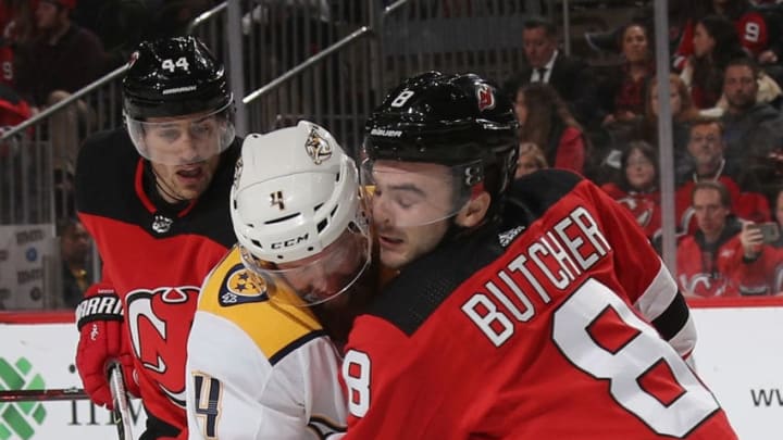 NEWARK, NEW JERSEY - OCTOBER 25: Ryan Ellis #4 of the Nashville Predators is checked by Will Butcher #8 of the New Jersey Devils during the third period at the Prudential Center on October 25, 2018 in Newark, New Jersey. The Predators defeated the Devils 4-3 in overtime. (Photo by Bruce Bennett/Getty Images)