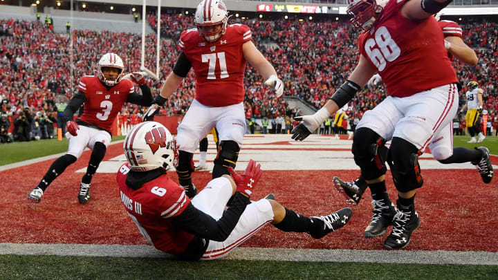 MADISON, WISCONSIN – NOVEMBER 09: Danny Davis III #6 of the Wisconsin Badgers celebrates with Kendric Pryor #3, Cole Van Lanen #71, and David Moorman #68 of the Wisconsin Badgers after scoring a touchdown in the first half against the Iowa Hawkeyes at Camp Randall Stadium on November 09, 2019 in Madison, Wisconsin. (Photo by Quinn Harris/Getty Images)
