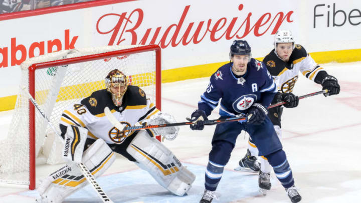 WINNIPEG, MB - MARCH 14: Mark Scheifele #55 of the Winnipeg Jets stands between goaltender Tuukka Rask #40 and Charlie McAvoy #73 of the Boston Bruins as they keep an eye on the play during third period action at the Bell MTS Place on March 14, 2019 in Winnipeg, Manitoba, Canada. The Jets defeated the Bruins 4-3. (Photo by Jonathan Kozub/NHLI via Getty Images)