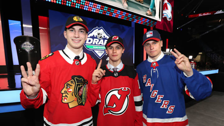 VANCOUVER, BRITISH COLUMBIA - JUNE 21: (L-R) Kirby Dach, third overall pick by the Chicago Blackhawks, Jack Hughes, first overall pick by the New Jersey Devils, and Kaapo Kakko, second overall pick by the New York Rangers, hold up their fingers of their pick order in front of the stage during the first round of the 2019 NHL Draft at Rogers Arena on June 21, 2019 in Vancouver, Canada. (Photo by Dave Sandford/NHLI via Getty Images)