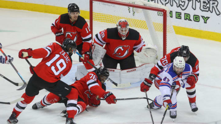 Mar 4, 2021; Newark, New Jersey, USA; New York Rangers center Colin Blackwell (43) and New Jersey Devils defenseman Dmitry Kulikov (70) battle for the puck after a save by goaltender Mackenzie Blackwood (29) during the first period at Prudential Center. Mandatory Credit: Ed Mulholland-USA TODAY Sports