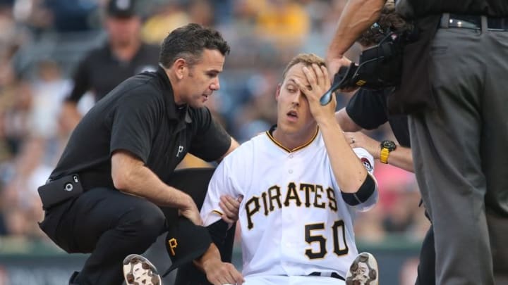 Jul 19, 2016; Pittsburgh, PA, USA; Pittsburgh Pirates starting pitcher Jameson Taillon (50) is attended to by trainer Ben Potenziano (left) after being struck with a line drive off the bat of Milwaukee Brewers third baseman Hernan Perez (not pictured) during the second inning at PNC Park. Mandatory Credit: Charles LeClaire-USA TODAY Sports