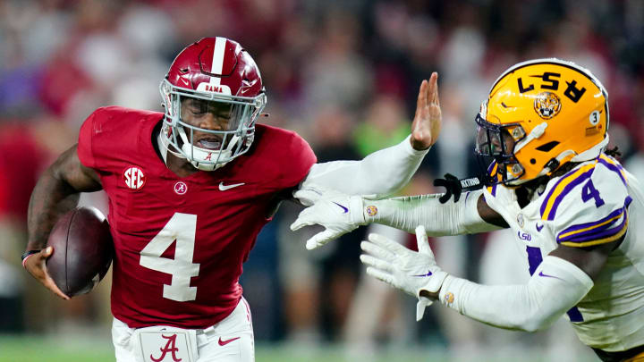 Nov 4, 2023; Tuscaloosa, Alabama, USA; Alabama Crimson Tide quarterback Jalen Milroe (4) scrambles up the field against LSU Tigers linebacker Harold Perkins Jr. (4) during the second half at Bryant-Denny Stadium. Alabama Crimson Tide defeated the LSU Tigers 42-28. Mandatory Credit: John David Mercer-USA TODAY Sports