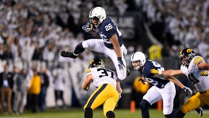 Nov 5, 2016; University Park, PA, USA; Penn State Nittany Lions running back Saquon Barkley (26) leaps over Iowa Hawkeyes defensive back Brandon Snyder (37) during the first quarter at Beaver Stadium. Mandatory Credit: Rich Barnes-USA TODAY Sports