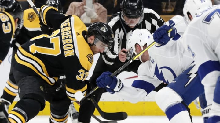 BOSTON, MA - FEBRUARY 28: Boston Bruins center Patrice Bergeron (37) and Tampa Bay Lightning center Steven Stamkos (91) jostle before linesman Kiel Murchison (79) drooped the puck during a game between the Boston Bruins and the Tampa Bay Lightning on February 28, 2019, at TD Garden in Boston, Massachusetts. (Photo by Fred Kfoury III/Icon Sportswire via Getty Images)
