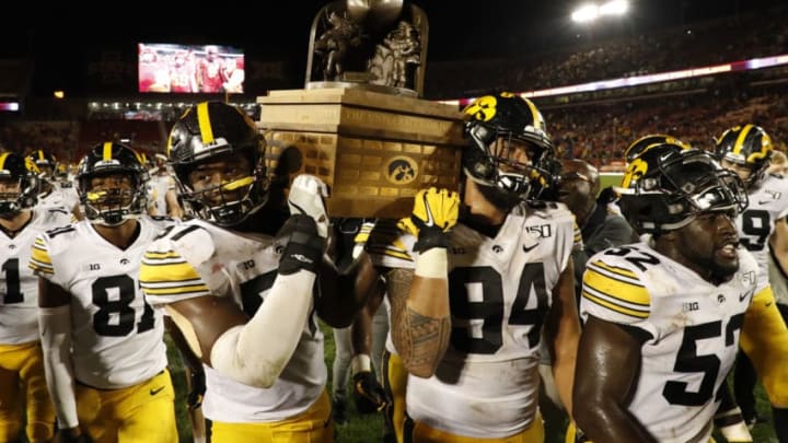 AMES, IA - SEPTEMBER 14: Defensive end Chauncey Golston #57, left, and defensive end A.J. Epenesa #94 of the Iowa Hawkeyes carry the Iowa Corn Cy-Hawk Trophy off the field after winning 18-17 over the Iowa State Cyclones at Jack Trice Stadium on September 14, 2019 in Ames, Iowa. The Iowa Hawkeyes won 18-17 over the Iowa State Cyclones. (Photo by David Purdy/Getty Images)