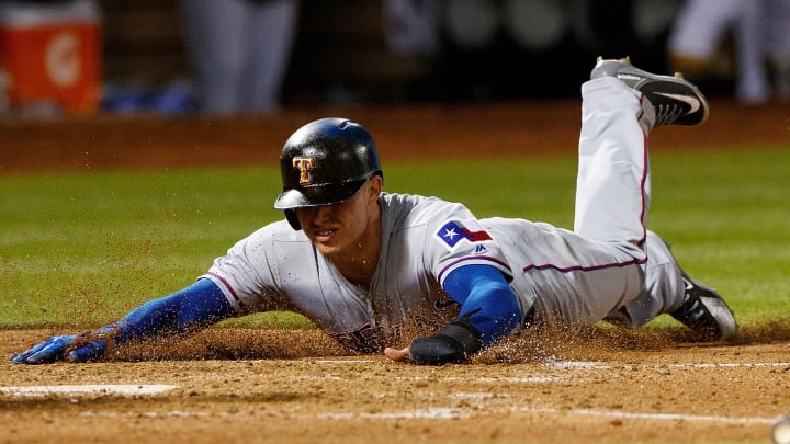 OAKLAND, CA – APRIL 02: Drew Robinson #18 of the Texas Rangers dives into home plate to score a run against the Oakland Athletics during the fifth inning at the Oakland Coliseum on April 2, 2018 in Oakland, California. The Oakland Athletics defeated the Texas Rangers 3-1. (Photo by Jason O. Watson/Getty Images)