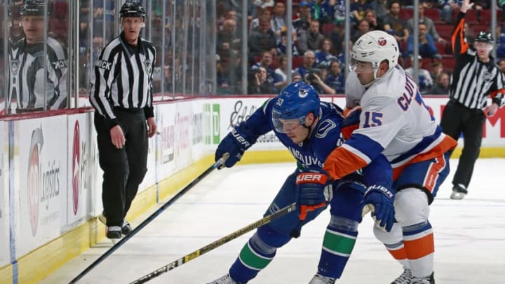 VANCOUVER, BC - FEBRUARY 23: Cal Clutterbuck #15 of the New York Islanders checks Bo Horvat #53 of the Vancouver Canucks during their NHL game at Rogers Arena February 23, 2019 in Vancouver, British Columbia, Canada. (Photo by Jeff Vinnick/NHLI via Getty Images)