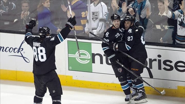 May 18, 2013; San Jose, CA, USA; San Jose Sharks center Logan Couture (39) is congratulated by defenseman Brent Burns (88) and center Scott Gomez (23) after scoring the game-winning goal against the Los Angeles Kings in overtime of game three of the second round of the 2013 Stanley Cup Playoffs at HP Pavilion. The San Jose Sharks defeated the Los Angeles Kings 2-1 in overtime. Mandatory Credit: Ed Szczepanski-USA TODAY Sports