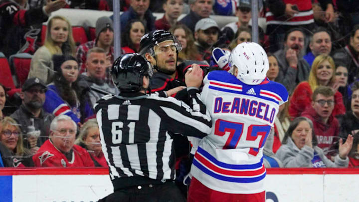 Feb 21, 2020; Raleigh, North Carolina, USA; Carolina Hurricanes right wing Nino Niederreiter (21) and New York Rangers defenseman Tony DeAngelo (77) battle in the third period at PNC Arena. The New York Rangers defeated the Carolina Hurricanes 5-2. Mandatory Credit: James Guillory-USA TODAY Sports