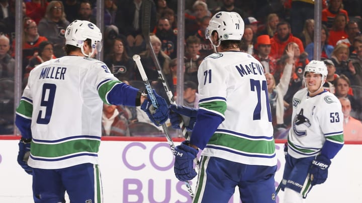 J.T. Miller #9 of the Vancouver Canucks celebrates with Zack MacEwen #71 and Bo Horvat #53Photo by Mitchell Leff/Getty Images)