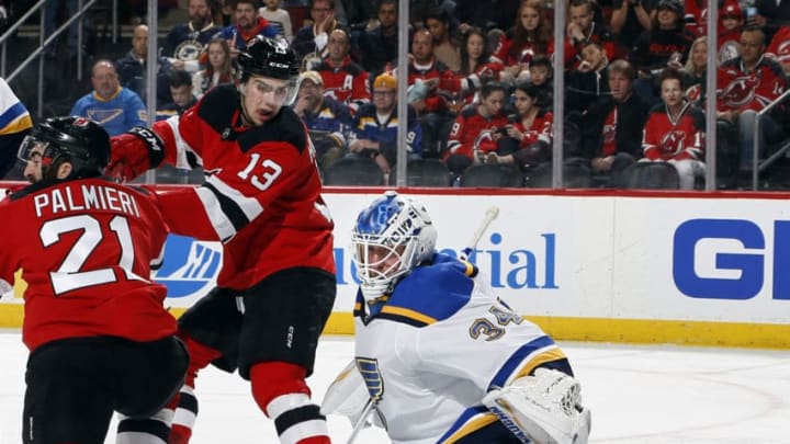 NEWARK, NJ - MARCH 30: Goalie Jake Allen #34 of the St. Louis Blues makes a save as Nico Hischier #13 of the New Jersey Devils looks over during an NHL hockey game at the Prudential Center in Newark, New Jersey. Blues won 3-2. (Photo by Paul Bereswill/Getty Images)