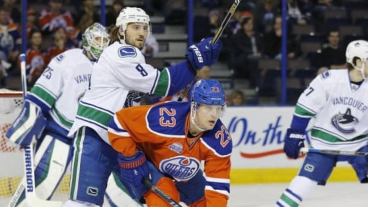 Mar 18, 2016; Edmonton, Alberta, CAN; Edmonton Oilers forward Matt Hendricks (23) and Vancouver Canucks defensemen Chris Tanev (8) battle in front of the Vancouver Canucks net during the first period at Rexall Place. Mandatory Credit: Perry Nelson-USA TODAY Sports