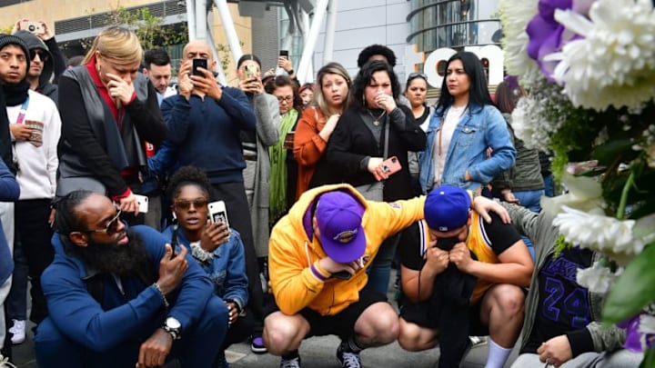 People gather around a makeshift memorial for former NBA and Los Angeles Lakers player Kobe Bryant after learning of his death at LA Live plaza in front of Staples Center in Los Angeles on January 26, 2020. - NBA legend Kobe Bryant died January 26, 2020 in a helicopter crash in suburban Los Angeles, celebrity website TMZ reported, saying five people are confirmed dead in the incident. (Photo by Frederic J. Brown / AFP) (Photo by FREDERIC J. BROWN/AFP via Getty Images)