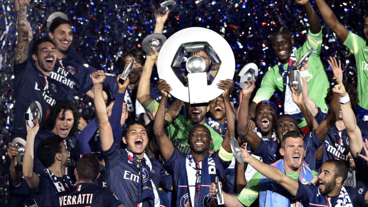 Paris Saint-Germain’s French defender Zoumana Camara (C)holds is trophy on the podium after winning the French L1 title at the end of the French L1 football match Paris Saint-Germain (PSG) vs Reims on May 23, 2015 at the Parc des Princes stadium in Paris. AFP PHOTO / FRANCK FIFE (Photo credit should read FRANCK FIFE/AFP/Getty Images)