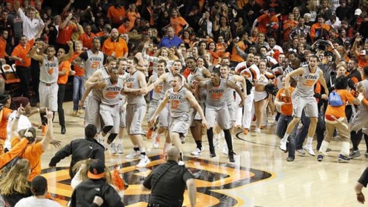 Mar 1, 2014; Stillwater, OK, USA; The Oklahoma State Cowboys and fans storm the court after defeating the Kansas Jayhawks at Gallagher-Iba Arena. Oklahoma State beat Kansas 72-65. Mandatory Credit: Tim Heitman-USA TODAY Sports