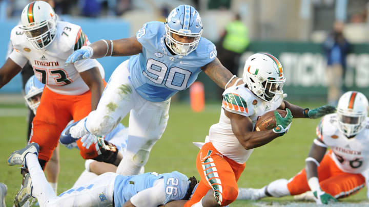 Nov 14, 2015; Chapel Hill, NC, USA; North Carolina Tar Heels safety Dominquie Green (26) and defensive tackle Nazair Jones (90) tackle Miami Hurricanes running back Mark Walton (1) at Kenan Memorial Stadium. The Tar Heels won 59 – 21. Mandatory Credit: Evan Pike-USA TODAY Sports