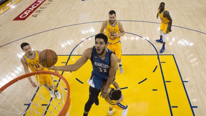 April 5, 2016; Oakland, CA, USA; Minnesota Timberwolves center Karl-Anthony Towns (32) commits an offensive foul charging into Golden State Warriors guard Stephen Curry (30) during the second half at Oracle Arena. The Timberwolves defeated the Warriors 124-117. Mandatory Credit: Kyle Terada-USA TODAY Sports