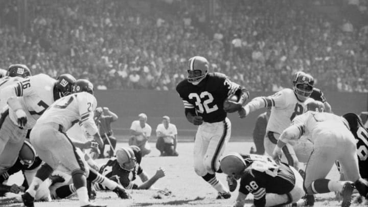 American professional football player Jim Brown #32 of the Cleveland Browns runs with the ball towards the defensive line of the New York Giants, Municipal Stadium, Cleveland, September 16, 1962. The Browns won 17 to 7. (Photo by Robert Riger/Getty Images)