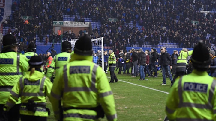 WIGAN, ENGLAND – FEBRUARY 19: Police hold back fans during a pitch invasion after the Emirates FA Cup Fifth Round match between Wigan Athletic and Manchester City at DW Stadium on February 19, 2018 in Wigan, England. (Photo by Gareth Copley/Getty Images)