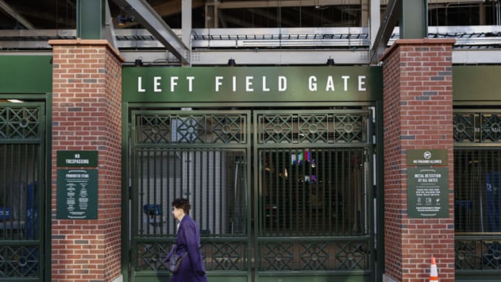 Dec 2, 2021; Chicago, IL, USA; A woman walks by locked Wrigley Field on the first day of Major League Baseball lockout. Mandatory Credit: Kamil Krzaczynski-USA TODAY Sports