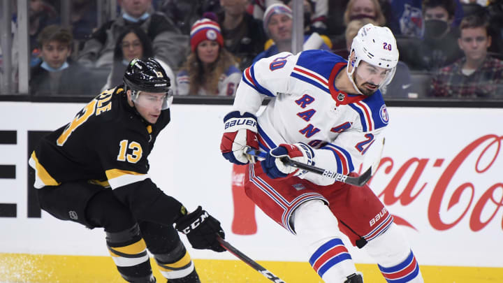Nov 26, 2021; Boston, Massachusetts, USA; New York Rangers left wing Chris Kreider (20) tries to gain control of the puck ahead of Boston Bruins center Charlie Coyle (13) during the second period at TD Garden. Mandatory Credit: Bob DeChiara-USA TODAY Sports