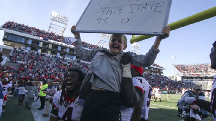 Nov 27, 2021; Atlanta, Georgia, USA; Georgia Bulldogs son of head coach Andrew Smart holds up a sign with running back James Cook (4) and offensive lineman Broderick Jones (59) after a victory against the Georgia Tech Yellow Jackets at Bobby Dodd Stadium. Mandatory Credit: Brett Davis-USA TODAY Sports