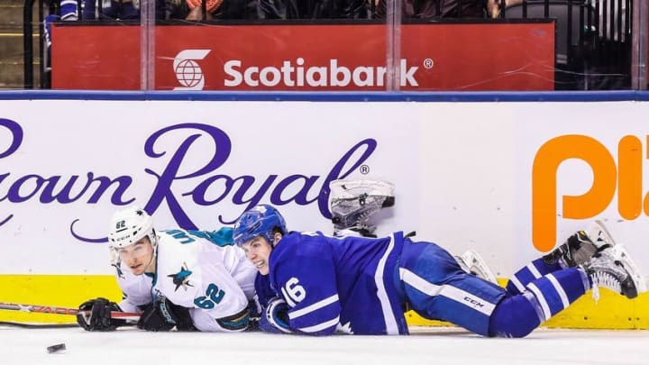 Dec 13, 2016; Toronto, Ontario, CAN; Toronto Maple Leafs center Mitch Marner (16) and San Jose Sharks right wing Kevin Labanc (62) fall as they go after the puck at Air Canada Centre. The Sharks beat the Maple Leafs 3-2 in the shootout. Mandatory Credit: Tom Szczerbowski-USA TODAY Sports
