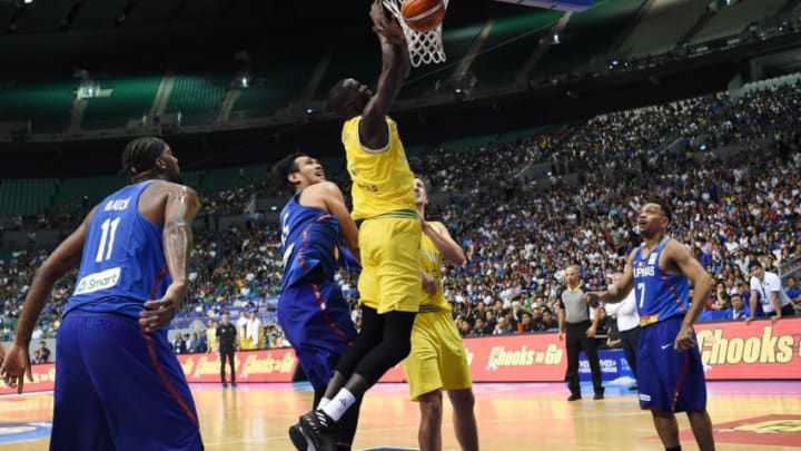 Australia's Thon maker (C, yellow) slums a dunk against June Fajardo (L) of the Philippines during their FIBA World Cup Asian qualifier game at the Philippine arena in Bocaue town, Bulacan province, north of Manila on July 2, 2018. - Australia won by default 89-53. (Photo by TED ALJIBE / AFP) (Photo credit should read TED ALJIBE/AFP/Getty Images)