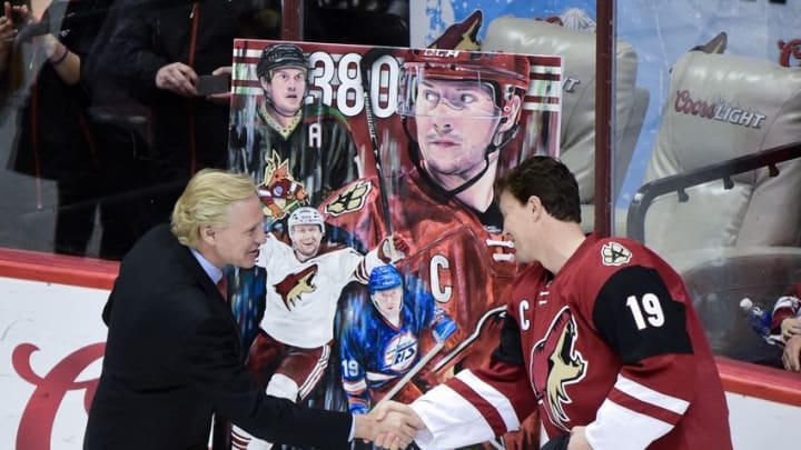 Jan 21, 2016; Glendale, AZ, USA; Arizona Coyotes general manager Don Maloney presents right wing Shane Doan (19) with a painting as part of a ceremony celebrating Doan as the Coyotes all time leading goal scorer with 380 prior to the game against the San Jose Sharks at Gila River Arena. Mandatory Credit: Matt Kartozian-USA TODAY Sports