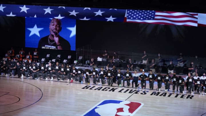 LAKE BUENA VISTA, FL - JULY 31: Members of the Milwaukee Bucks and the Boston Celtics kneel around a Black Lives Matter logo before the start of an NBA basketball game Friday, July 31, 2020, in Lake Buena Vista, Florida. NOTE TO USER: User expressly acknowledges and agrees that, by downloading and or using this photograph, User is consenting to the terms and conditions of the Getty Images License Agreement. (Photo by Ashley Landis-Pool/Getty Images)